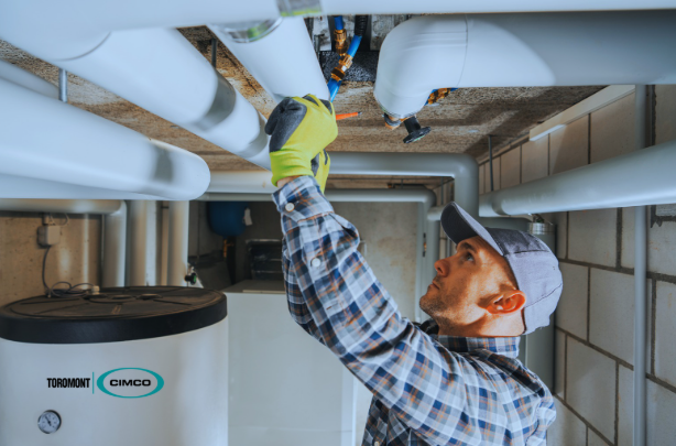 Technician inspecting piping and equipment in a plant room