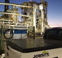 A jobsite truck in front of a petrochemical plant